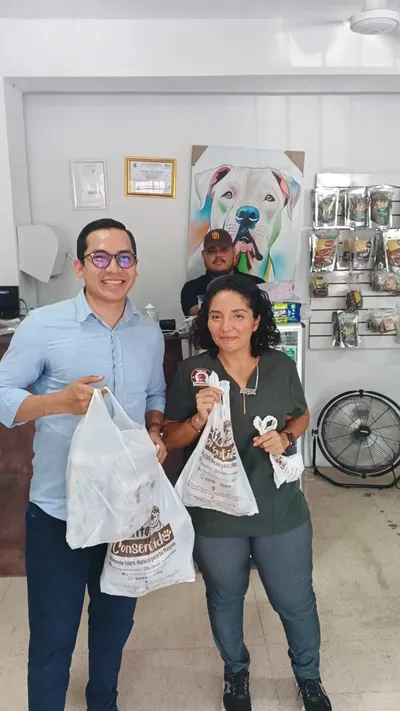 Clientes en tienda con bolsas Conservito, promoción de alimento 100% natural para mascotas en México.